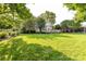 Large, well-maintained backyard with lush greenery, mature trees, and a wooden deck at 4637 Shannamara Dr, Matthews, NC 28104