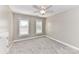 A cozy bedroom featuring neutral paint, plush carpeting, two windows, and a ceiling fan at 4637 Shannamara Dr, Matthews, NC 28104