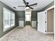 Modern bedroom with neutral carpet, ample natural light, and a ceiling fan fixture at 4637 Shannamara Dr, Matthews, NC 28104