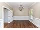 Formal dining room featuring hardwood floors, wainscoting, chandelier, and abundant natural light at 4637 Shannamara Dr, Matthews, NC 28104