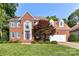 Charming two-story brick home with lush lawn, mature trees, and attached two-car garage at 4637 Shannamara Dr, Matthews, NC 28104