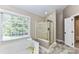 Bright bathroom with a garden tub, separate shower, and a large window providing natural light at 4637 Shannamara Dr, Matthews, NC 28104