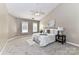Spacious main bedroom featuring a ceiling fan, plush carpeting, and natural light from two windows at 4637 Shannamara Dr, Matthews, NC 28104