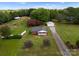 Expansive property featuring a charming brick home with lush landscaping, outbuildings, and a long driveway at 5170 Woodleaf Rd, Salisbury, NC 28147