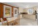 Cozy kitchen features wooden wall accents, cream cabinets, and a sunny breakfast nook with a table at 5170 Woodleaf Rd, Salisbury, NC 28147