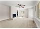 Bright living room features a classic brick fireplace, neutral carpet, and ample natural light from large windows at 5170 Woodleaf Rd, Salisbury, NC 28147
