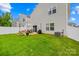 Lush backyard with a patio area for entertaining, surrounded by green grass and a white fence at 5204 Belstone Ln, Charlotte, NC 28215