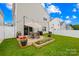A fenced backyard features patio seating, greenery, and glimpses of neighboring homes at 5204 Belstone Ln, Charlotte, NC 28215