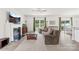 Spacious living room with fireplace, large windows, and comfortable seating area at 5204 Belstone Ln, Charlotte, NC 28215