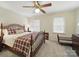 A light filled bedroom with a ceiling fan and queen sized bed dressed in a colorful plaid blanket at 550 Burrage Ne Rd, Concord, NC 28025