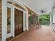 Inviting front porch featuring brick flooring, rocking chair, and ceiling fan at 550 Burrage Ne Rd, Concord, NC 28025