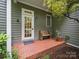 Charming front porch entrance with a wooden bench and well-kept landscaping at 550 Burrage Ne Rd, Concord, NC 28025