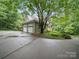 Detached two-car garage showcasing ample parking space, a manicured lawn, and mature trees at 550 Burrage Ne Rd, Concord, NC 28025