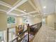 View of the living room from the top of the stairwell, complete with fireplace and coffered ceilings at 550 Burrage Ne Rd, Concord, NC 28025
