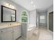A bright bathroom has a window above the garden tub and white sink with cabinets at 550 Burrage Ne Rd, Concord, NC 28025