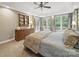 The large main bedroom features windows overlooking green space and a vintage wooden dresser at 550 Burrage Ne Rd, Concord, NC 28025