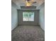 Bedroom featuring a tray ceiling, neutral carpet, and a large window at 5821 Tuckaseegee Rd, Charlotte, NC 28208