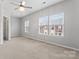 Sunlit bedroom with plush neutral carpet, two windows, and three doorways at 6309 Margaret Ct, Indian Trail, NC 28079