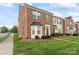 Charming brick townhome with a manicured lawn and green shutters on a sunny day at 6309 Margaret Ct, Indian Trail, NC 28079