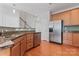 Well-lit kitchen with stainless steel appliances, including a refrigerator and dishwasher, and wooden cabinetry at 6309 Margaret Ct, Indian Trail, NC 28079