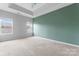 Carpeted primary bedroom featuring a vaulted ceiling, natural light, and calming green accent wall at 6309 Margaret Ct, Indian Trail, NC 28079