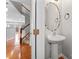 Stylish powder room with a pedestal sink, decorative mirror, and hardwood floors at 6309 Margaret Ct, Indian Trail, NC 28079