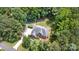 Aerial view of a home surrounded by lush greenery, showcasing a well-manicured yard, outdoor patio, and firepit at 6419 Antioch Ct, Matthews, NC 28104