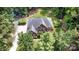 Aerial shot of a brick home with a large yard, surrounded by lush trees, and outdoor amenities at 6419 Antioch Ct, Matthews, NC 28104