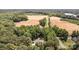 Expansive aerial view of property, surrounded by dense trees and a road running along the edge at 6419 Antioch Ct, Matthews, NC 28104