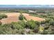 Stunning aerial view of the property showcasing its vast landscape with fields, trees, and a serene lake in the distance at 6419 Antioch Ct, Matthews, NC 28104