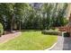 Lush backyard featuring a cozy fire pit, green garden beds, and access to a wooden deck at 6419 Antioch Ct, Matthews, NC 28104