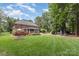 Expansive backyard with lush lawn, wooden deck, fire pit, and mature trees, perfect for outdoor activities at 6419 Antioch Ct, Matthews, NC 28104
