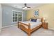 Cozy bedroom featuring light yellow walls, wood furniture, a ceiling fan, carpet, and a window with a wooded view at 6419 Antioch Ct, Matthews, NC 28104
