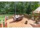 Spacious wooden deck with dining table and chairs, surrounded by lush trees, ideal for outdoor gatherings at 6419 Antioch Ct, Matthews, NC 28104