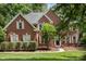 Charming two-story brick home with manicured landscaping, shutters, and a welcoming front entrance at 6419 Antioch Ct, Matthews, NC 28104