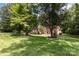 Manicured front lawn leads to a traditional brick home, shaded by mature trees, with well-maintained landscaping at 6419 Antioch Ct, Matthews, NC 28104