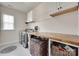 Functional laundry room with a washer, dryer, storage cabinets, and a countertop for folding at 645 Brookhaven Dr, Fort Mill, SC 29708