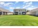 Expansive backyard with well-manicured lawn, framed by a dark metal fence and features dual pergolas on the patio at 7414 Meridale Forest Dr, Charlotte, NC 28269