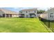 Large backyard with a dark metal fence, green lawn, and pergola covered patios for outdoor enjoyment at 7414 Meridale Forest Dr, Charlotte, NC 28269