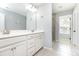 Bright bathroom featuring a double sink vanity with white cabinets, tiled floors, and separate glass shower at 7414 Meridale Forest Dr, Charlotte, NC 28269