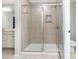 Contemporary bathroom with a glass-enclosed shower featuring tiled walls, a built-in niche, and modern fixtures at 7414 Meridale Forest Dr, Charlotte, NC 28269