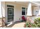 Inviting front porch with decorative door, stone accents, and comfortable seating at 7414 Meridale Forest Dr, Charlotte, NC 28269