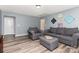 Charming living room showcases gray walls, wood flooring, comfortable gray seating, and decorative wall art at 7414 Meridale Forest Dr, Charlotte, NC 28269