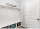 Convenient mudroom with built-in bench, storage cubbies, and coat hooks near door at 7414 Meridale Forest Dr, Charlotte, NC 28269