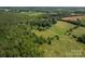 Aerial view of the property featuring an in-ground pool, outbuildings, and a serene, wooded setting at 7660 Bud Davis Rd, Vale, NC 28168