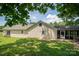 View of the house's rear facade, including a screened-in porch, and a lush, grassy backyard at 7660 Bud Davis Rd, Vale, NC 28168