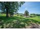 Spacious backyard with mature trees, playground, and an in-ground pool at 7660 Bud Davis Rd, Vale, NC 28168