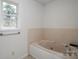 Comfortable bathtub under window features tiled walls and updated fixtures at 7660 Bud Davis Rd, Vale, NC 28168