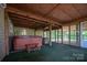 View of a covered patio featuring a hot tub, stone cooking area, and green turf flooring at 7660 Bud Davis Rd, Vale, NC 28168