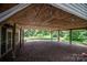 Covered patio with wood beams, a stone-covered floor, and a view of the lush backyard at 7660 Bud Davis Rd, Vale, NC 28168